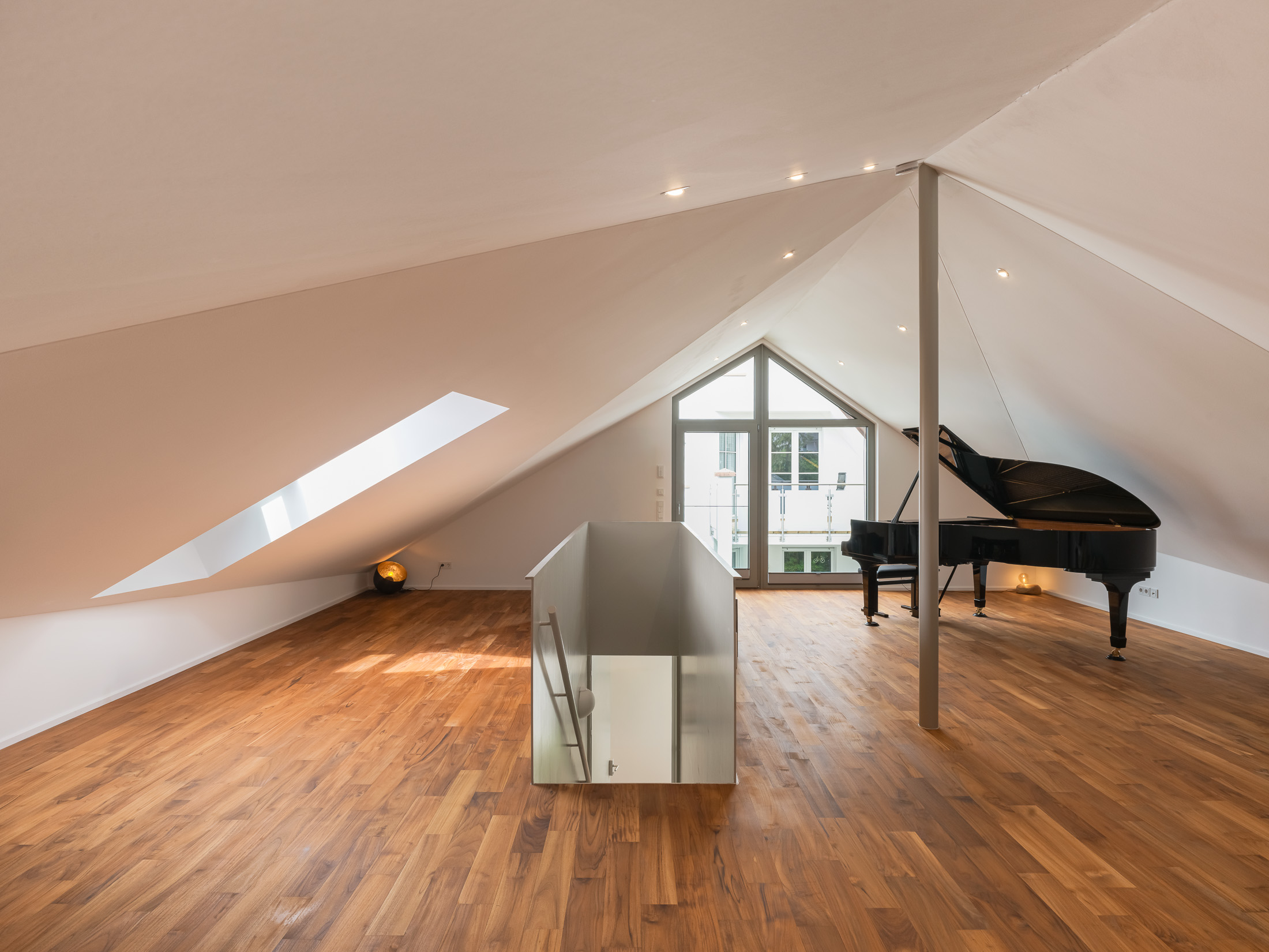 Ausgebautes Musikstudio im Dachraum mit einem Konzertflügel und großem Panoramafenster mit weitem Blick in die Rheinebene.