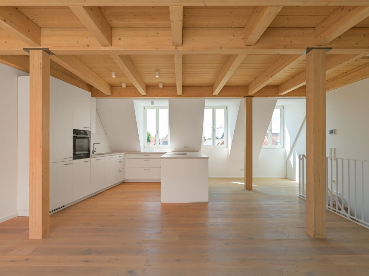 Neubau eines modernen Mehrfamilienhauses - offener Küchenbereich mit traditionellen Gauben und Sichtbalkendecke