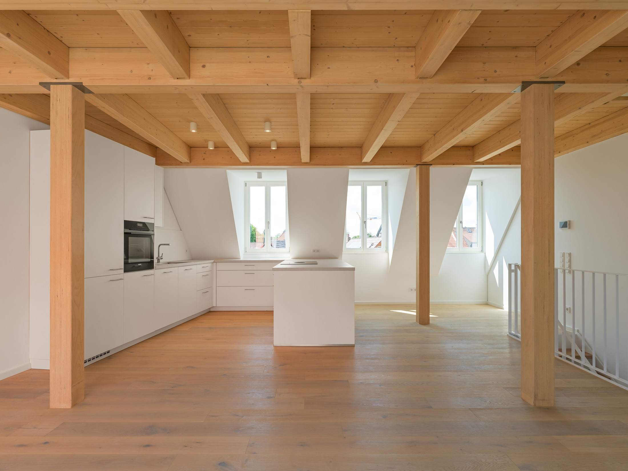 Neubau eines modernen Mehrfamilienhauses - offener Küchenbereich mit traditionellen Gauben und Sichtbalkendecke