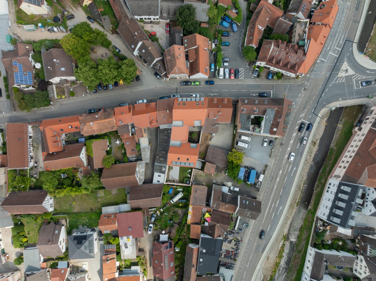 Neubau eines modernen Mehrfamilienhauses mit begrüntem Innenhof im historischen Kontext - Luftbildaufnahme