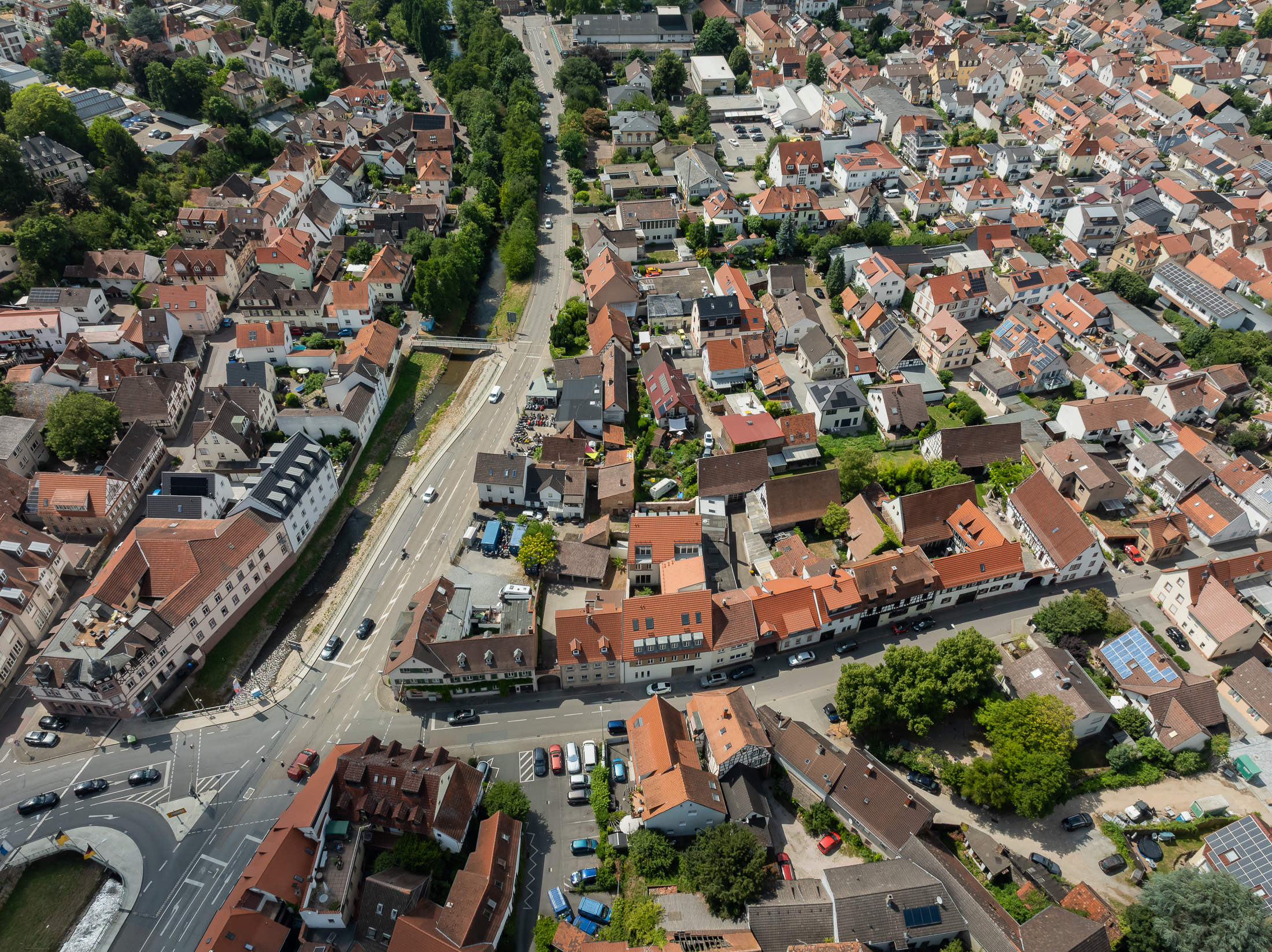 Neubau eines modernen Mehrfamilienhauses mit begrüntem Innenhof im historischen Kontext mit Besenstrichputz, Holzschalung, Schiebeläden und modernen Gauben.