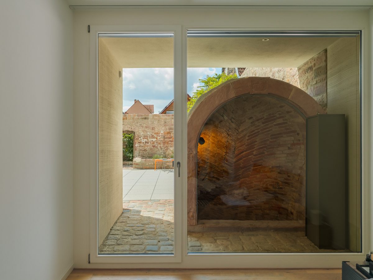 Neubau eines modernen Mehrfamilienhauses -Zugang zum historischen Gewölbekeller und Blick in den begrünten privaten Gartenhof