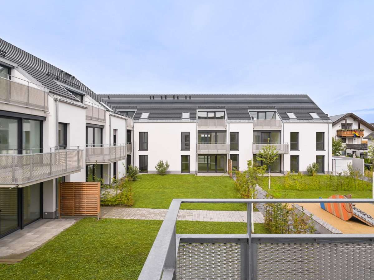 Mehrfamilienhausanlage für die VOLKSWOHNUNG GmbH in Karlsruhe-Durlach mit zweigeschossigen Hausgruppen und prägnanten Satteldächern, die sich um zwei begrünte, geschützte Innenhöfe organisieren; großzügige Verglasungen, Loggien und Dachgauben sowie eine flächenbündig integrierte Indach-Photovoltaikanlage prägen das architektonische Erscheinungsbild.