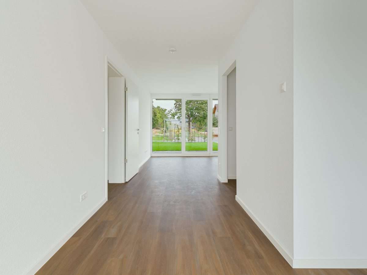 Mehrfamilienhausanlage für die VOLKSWOHNUNG GmbH in Karlsruhe-Durlach mit zweigeschossigen Hausgruppen und prägnanten Satteldächern, die sich um zwei begrünte, geschützte Innenhöfe organisieren; großzügige Verglasungen, Loggien und Dachgauben sowie eine flächenbündig integrierte Indach-Photovoltaikanlage prägen das architektonische Erscheinungsbild.