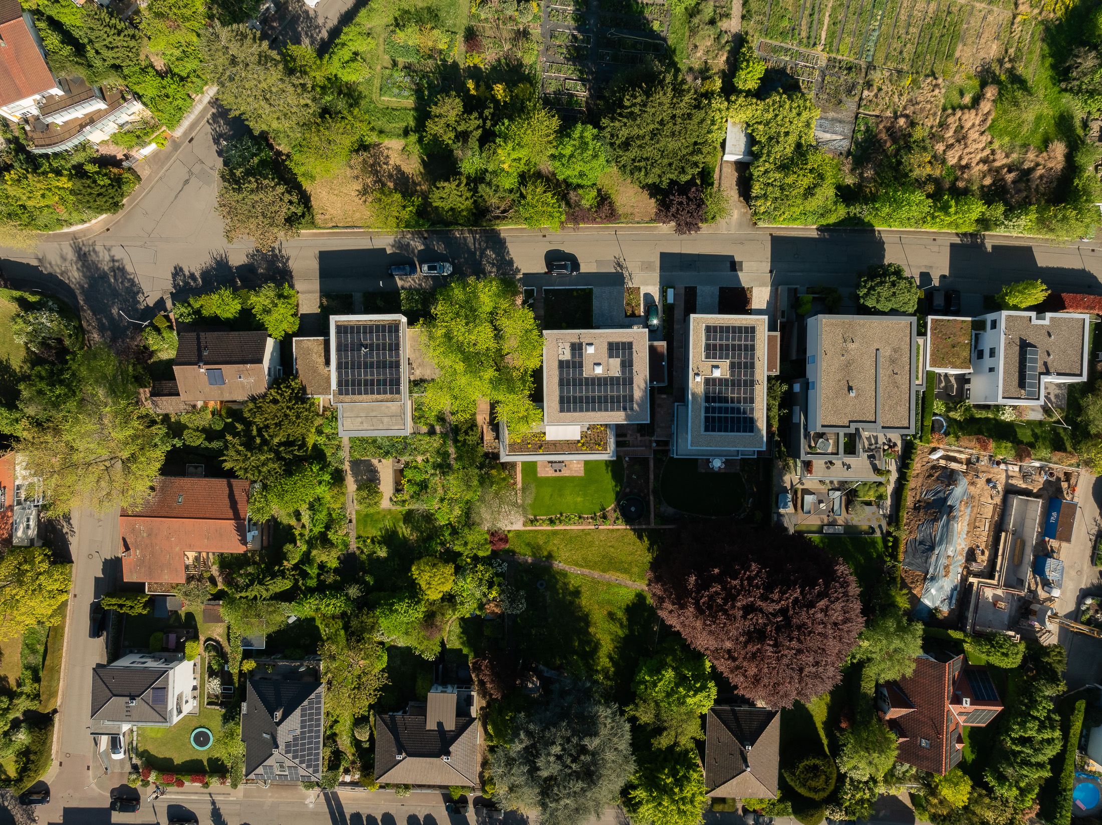 Architekturprojekt „Weiterbauen“ in Weinheim von Weber und Partner Architekten: Gesamtansicht der nachverdichteten Unternehmervilla aus den 1950er Jahren im parkartigen Hanggrundstück. Der gekürzte Bestandsbau mit hellen Klinkern und Holzaufstockung verbindet sich durch den Sandsteinsockel mit dem modernen Erweiterungsbau aus Massivholz.