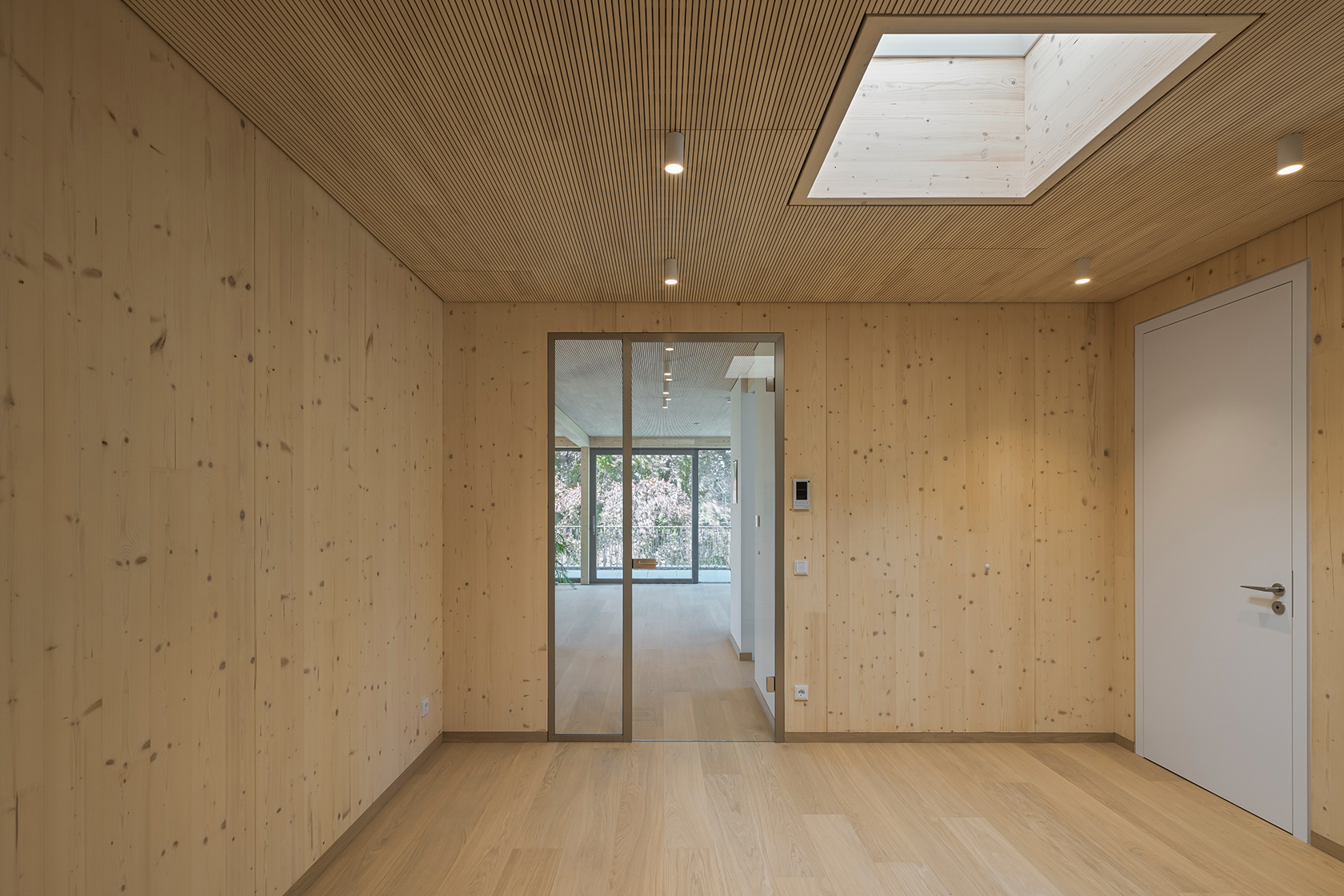 Architekturprojekt „Weiterbauen“ in Weinheim von Weber und Partner Architekten: Gesamtansicht der nachverdichteten Unternehmervilla aus den 1950er Jahren im parkartigen Hanggrundstück. Der gekürzte Bestandsbau mit hellen Klinkern und Holzaufstockung verbindet sich durch den Sandsteinsockel mit dem modernen Erweiterungsbau aus Massivholz.