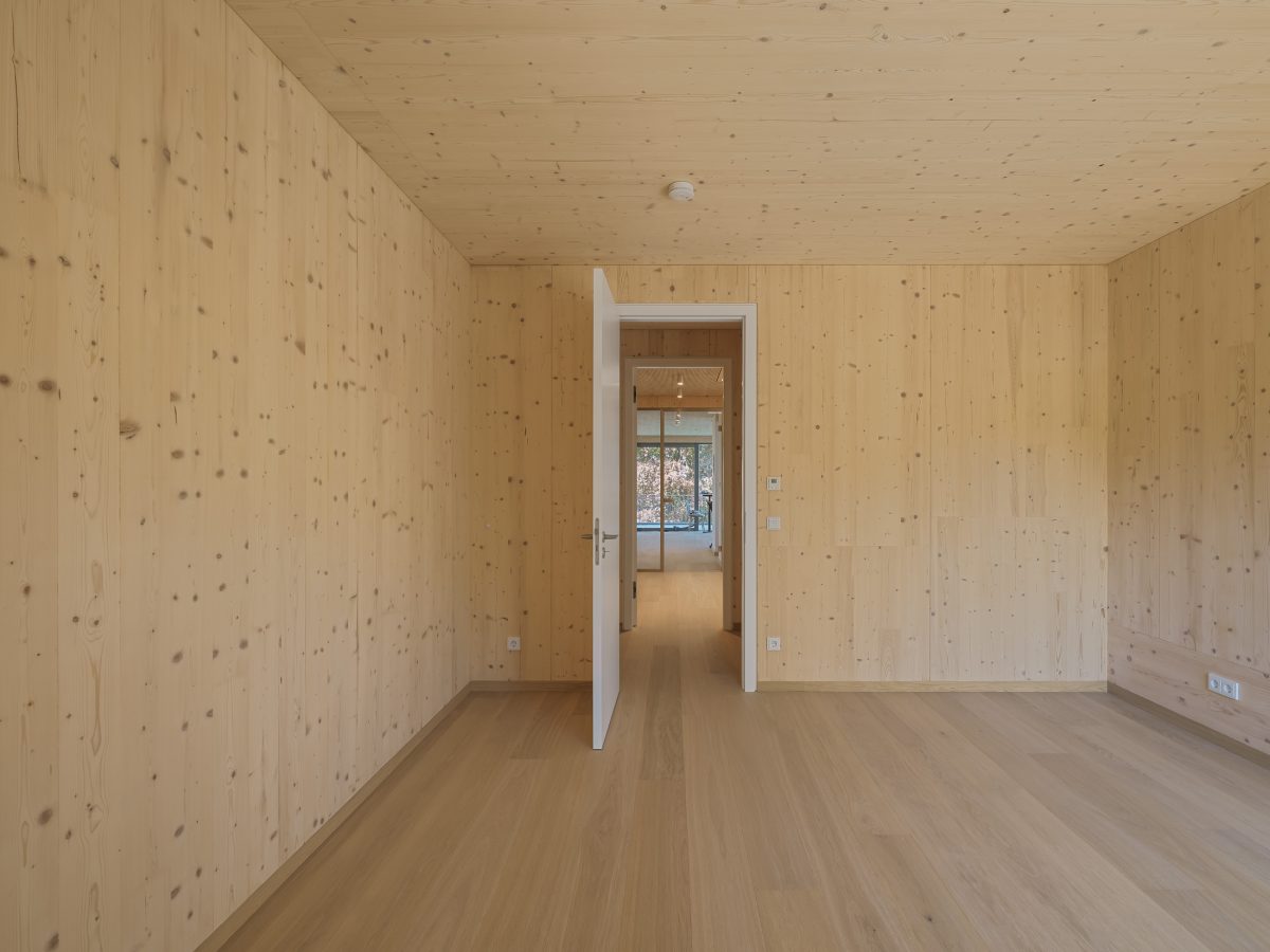 Architekturprojekt „Weiterbauen“ in Weinheim von Weber und Partner Architekten: Gesamtansicht der nachverdichteten Unternehmervilla aus den 1950er Jahren im parkartigen Hanggrundstück. Der gekürzte Bestandsbau mit hellen Klinkern und Holzaufstockung verbindet sich durch den Sandsteinsockel mit dem modernen Erweiterungsbau aus Massivholz.