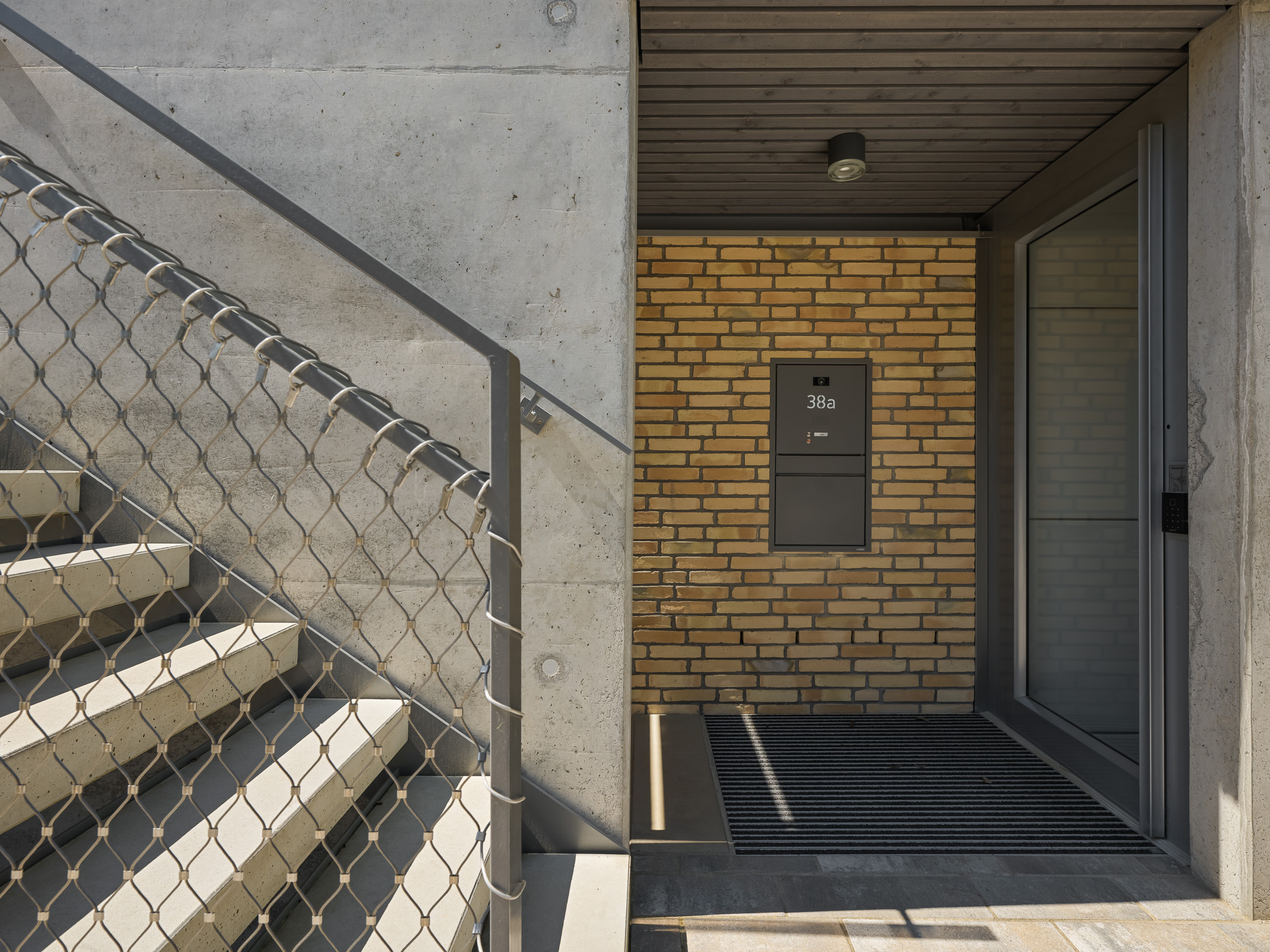 Architekturprojekt „Weiterbauen“ in Weinheim von Weber und Partner Architekten: Gesamtansicht der nachverdichteten Unternehmervilla aus den 1950er Jahren im parkartigen Hanggrundstück. Der gekürzte Bestandsbau mit hellen Klinkern und Holzaufstockung verbindet sich durch den Sandsteinsockel mit dem modernen Erweiterungsbau aus Massivholz.