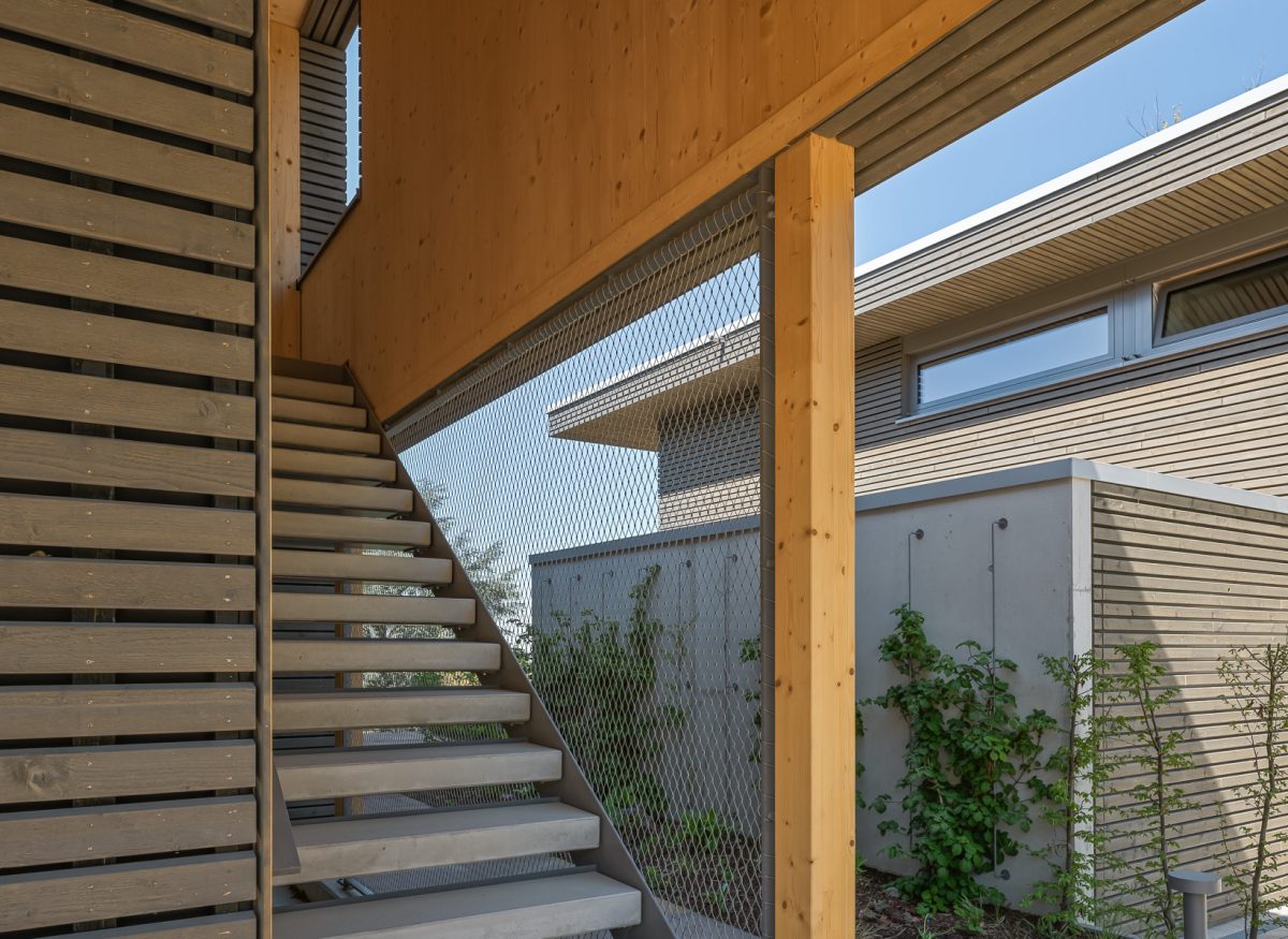 Architekturprojekt „Weiterbauen“ in Weinheim von Weber und Partner Architekten: Gesamtansicht der nachverdichteten Unternehmervilla aus den 1950er Jahren im parkartigen Hanggrundstück. Der gekürzte Bestandsbau mit hellen Klinkern und Holzaufstockung verbindet sich durch den Sandsteinsockel mit dem modernen Erweiterungsbau aus Massivholz.