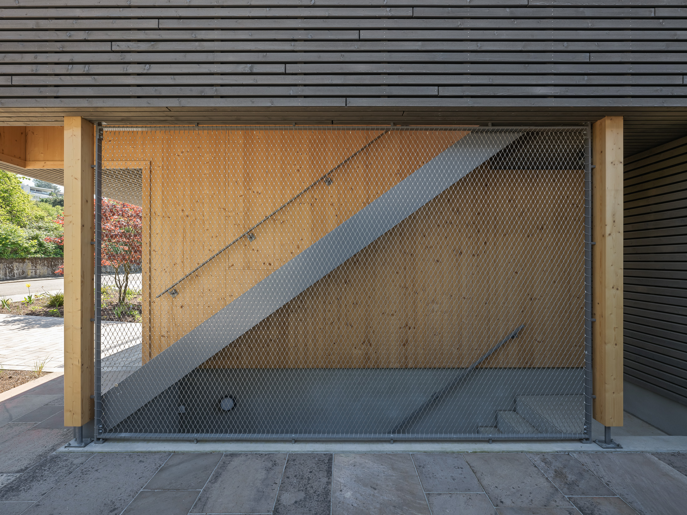 Architekturprojekt „Weiterbauen“ in Weinheim von Weber und Partner Architekten: Gesamtansicht der nachverdichteten Unternehmervilla aus den 1950er Jahren im parkartigen Hanggrundstück. Der gekürzte Bestandsbau mit hellen Klinkern und Holzaufstockung verbindet sich durch den Sandsteinsockel mit dem modernen Erweiterungsbau aus Massivholz.